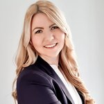 Frau mit langen blonden Haaren lächelt seitlich in die Kamera | © Jasmin Pampuch