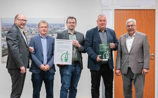 Setzen mit der Klimakooperation Fischereihafen CCF gemeinsam die Segel für eine CO₂-neutrale Zukunft und nehmen den Innovationspreis „Motor des Nordens“ von Oberbürgermeister Melf Grantz (ganz rechts) sowie Olaf Reichert, Vorstand Powerhouse Nord (ganz links) für das Bündnis in Empfang (v.l.): Timo Mahler (Leitung Energiemanagement, Deutsche See); Dr. Alexander David (Erneuerbare Energien, FBG); Ralf Finck (Einkauf Energie & Technik, FRoSTA). | © Magistratspressestelle / Arnd Hartmann