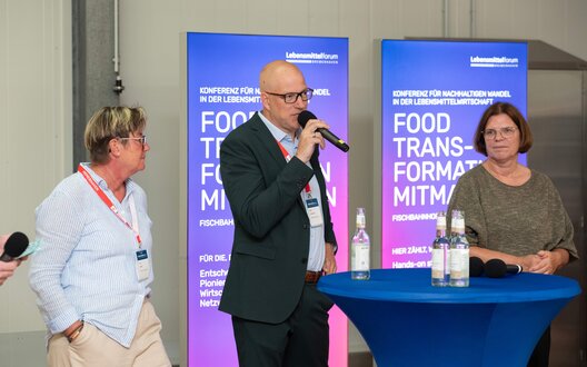 Diskutieren die Zukunft der Lebensmittelwirtschaft bei der Eröffnung auf dem Bremerhavener Lebensmittelforum 2025 (v.l.): Insa Rabbel (BIS Wirtschaftsförderung Bremerhaven), Mirko Oeltermann (BÄKO Bremerhaven), Senatorin für Wirtschaft, Häfen und Transformation Kristina Vogt. Aus der Podiumsdiskussion nicht auf dem Bild: Oberbürgermeister Melf Grantz, Benjamin Küther (TTZ Bremerhaven).  | © BIS / David Farcas