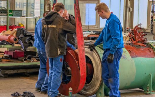 Ein Mann erklärt mehreren jüngeren Männer eine Aufgabe. | © BIS mbH