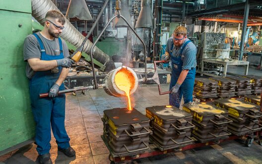 Zwei Männer gießen ein Metallteil. | © Grote Media/BIS