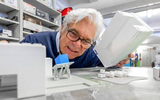 Gerhard Schories betrachtet ein kleines Modell