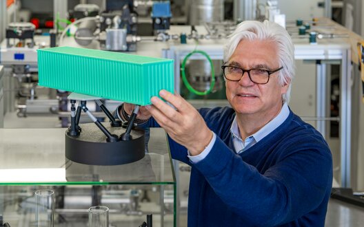 Prof. Dr.-Ing. Gerhard Schories mit einem Modell des Seegangssimulators | © WFB/Björn Hake 