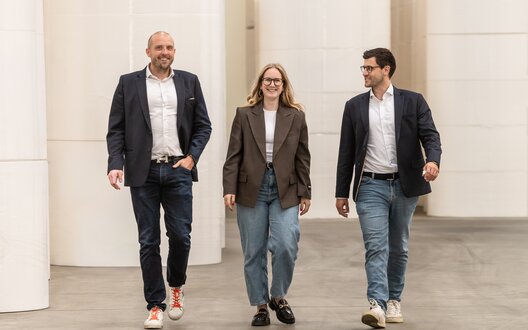 Drei Menschen laufen nebeneinander her und lächeln. | © BIS Bremerhaven/W. Heumer 