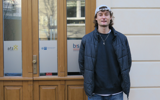 Ein Mann steht vor einem Haus und lächelt. | © BIS/ K. Müller 