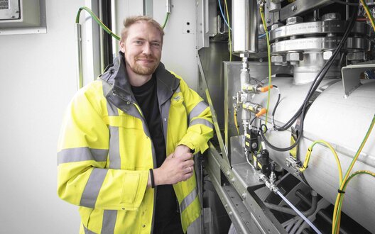 Kevin Schalk vor einem der beiden IWES-Elektrolyseure | © WFB/Jens Lehmkühler   